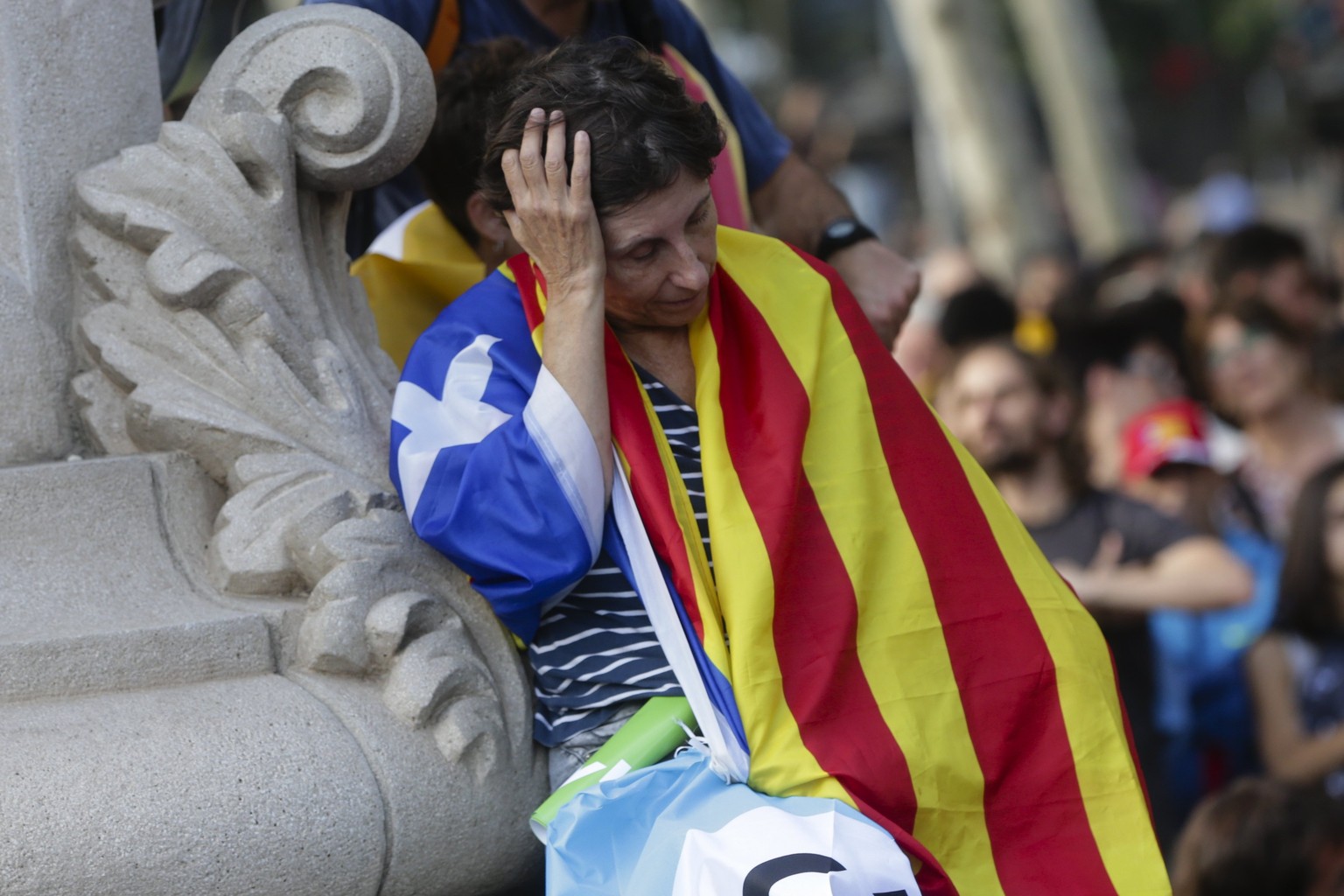 epa06257577 A man reacts as people gather to follow the speech of the Catalan President Carles Puigdemont in the regional Parliament, in downtown Barcelona, Spain, 10 October 2017. Puigdemont has prop ...