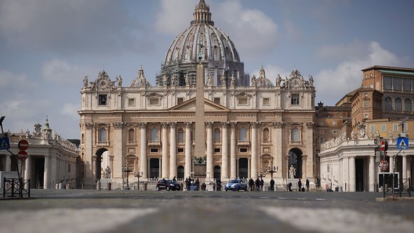 ARCHIV - Polizeiautos und Beamte patrouillieren auf dem leeren Petersplatz. Die Neuordnung der Geldströme im Vatikan soll mehr Transparenz bringen. Foto: Andrew Medichini/AP/dpa