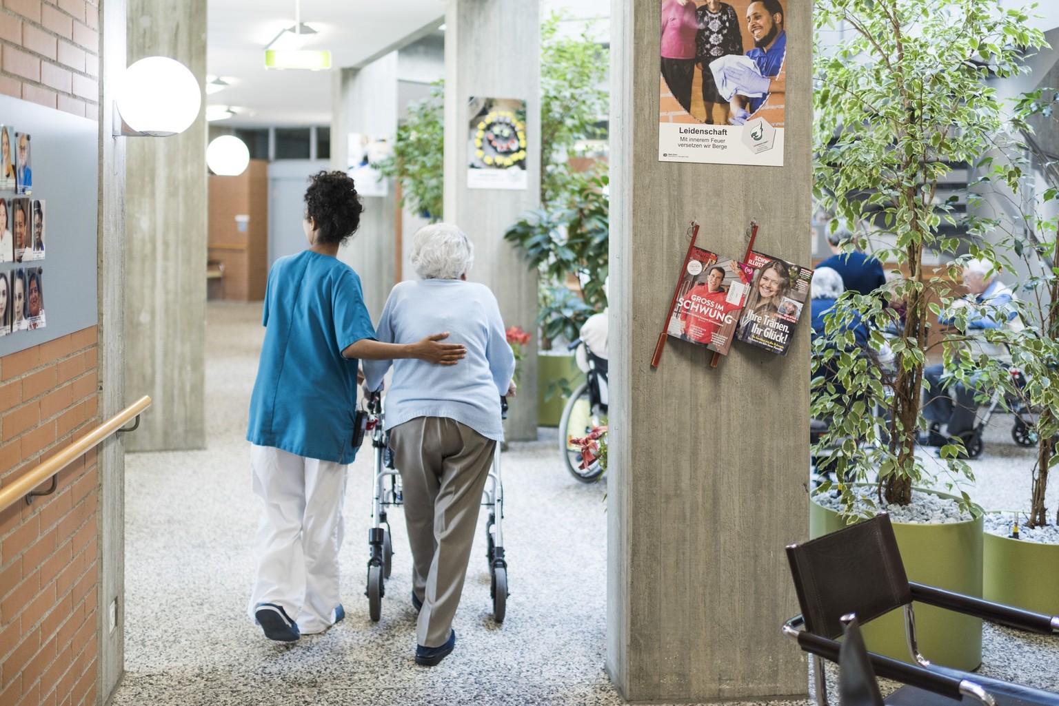 A nurse walks next to a resident of the retirement home Herzogenmuehle in Zurich, Switzerland, on February 21, 2019. (KEYSTONE/Christian Beutler)