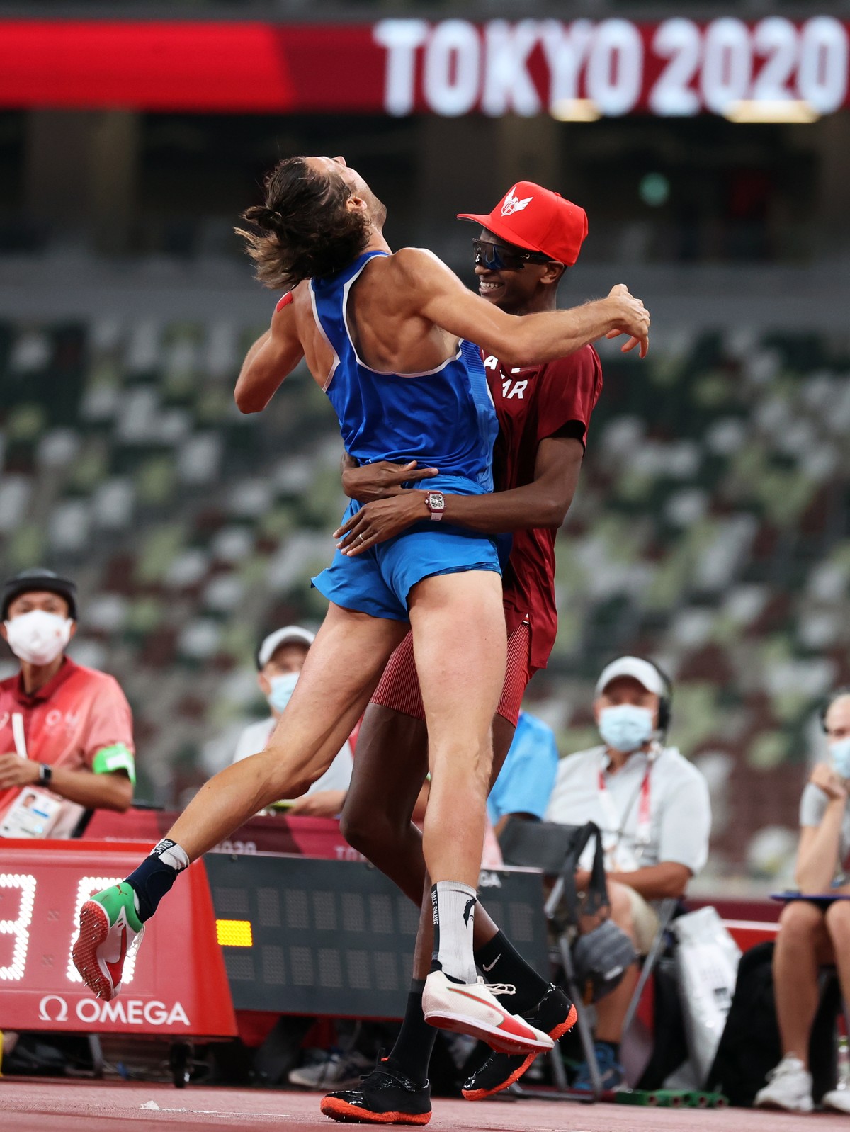 epa09385577 Gold Medalists Gianmarco Tamberi of Italy (L) and Essa Mutaz Barshim of Qatar (R) react after the Men's High Jump Final during the Athletics events of the Tokyo 2020 Olympic Games at  ...