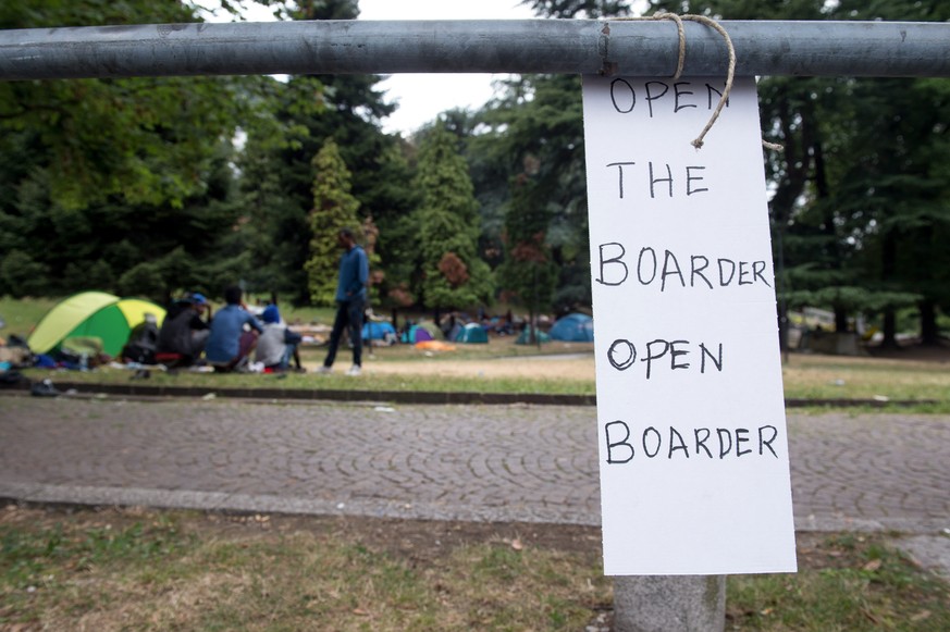 A sign written with &quot;Open the boarder&quot; is pictured, where refugees heading towards northern Europe have set up tents in a park close to the train station in Como, Italy, on Friday, August 19 ...