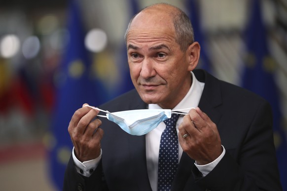 FILE - In this July 17, 2020 file photo, Slovenia&#039;s Prime Minister Janez Jansa takes off his protective face mask in Brussels. Slovenia takes over the European Union presidency with its prime min ...