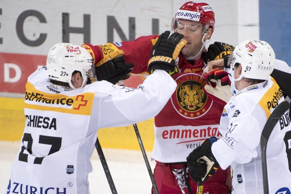 Langnaus Cam Barker, Mitte, kaempft gegen Luganos Alessandro Chiesa, links, und Dario Buergler, rechts, waehrend dem Meisterschaftsspiel der National League zwischen den SCL Tigers und dem HC Lugano,  ...