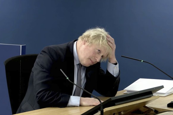 This image taken from the UK COVID-19 Inquiry live stream shows former British prime minister Boris Johnson giving evidence at Dorland House in London, Wednesday Dec. 6, 2023, during its second invest ...