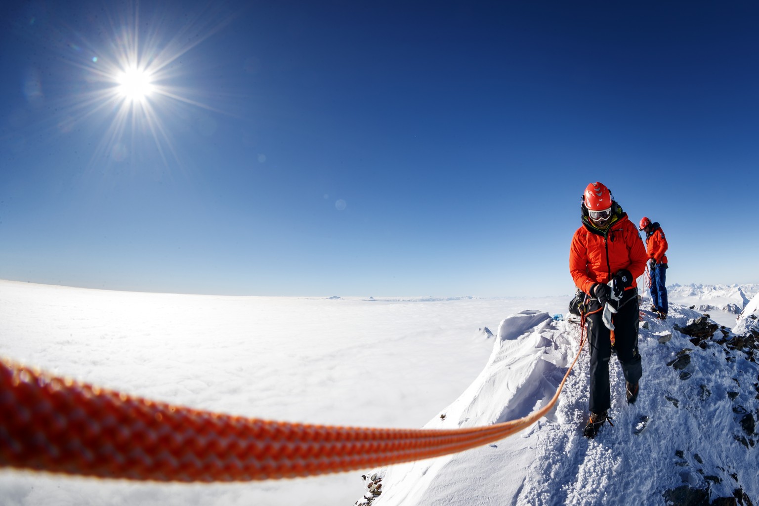 Alpine guides wait for a helicopter after a symbolic torch was lit in support of the &quot;Sion 2026&quot; winter Olympic Games candidacy project, on the summit of the iconic Matterhorn mountain peaki ...