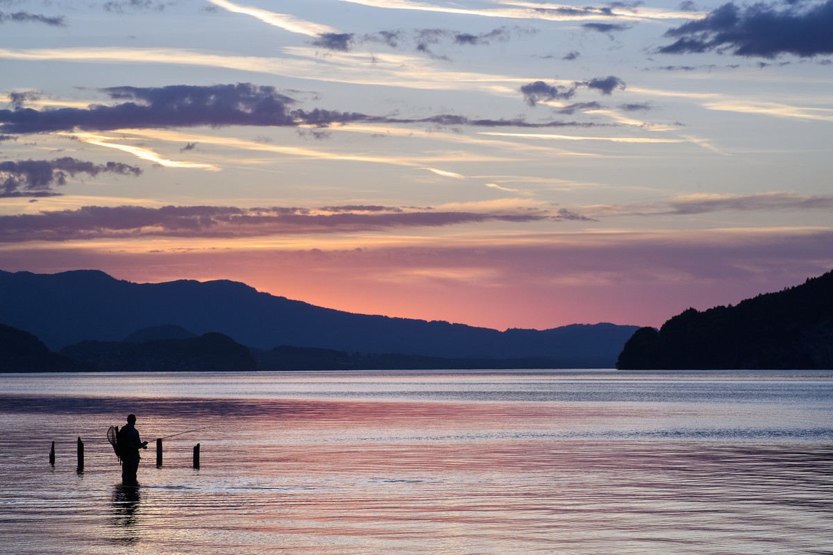 A fisherman fishing in Lake Thun during a beautiful sunset in springtime next to Daerligen in the Bernese Oberland, Switzerland, this Friday, April 27, 2018. (KEYSTONE/Anthony Anex)