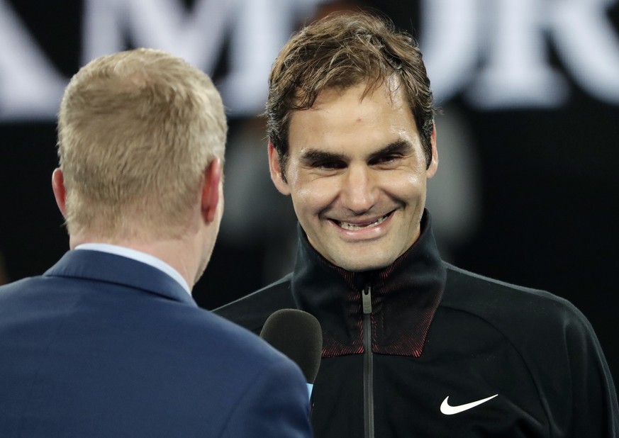 Switzerland&#039;s Roger Federer smiles as he is interviewed by former champion Jim Courier after defeating Tomas Berdych of the Czech Republic in their quarterfinal at the Australian Open tennis cham ...