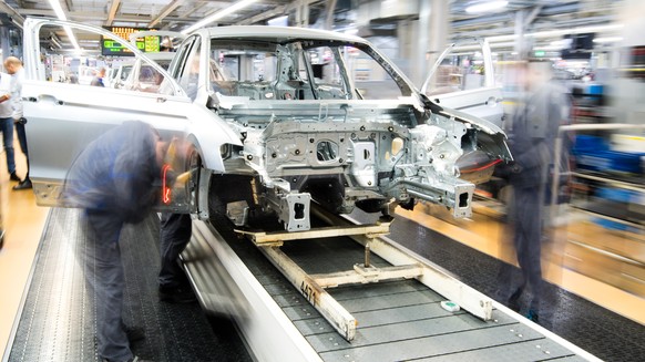 ARCHIV --- Mitarbeiter montieren am 1. Maerz 2019 Kotfluegel an einen Volkswagen Golf VII im Karosseriebau im VW Werk in Wolfsburg, Deutschland. (Aufnahme mit langer Verschlusszeit). (zu dpa &quot;Vol ...