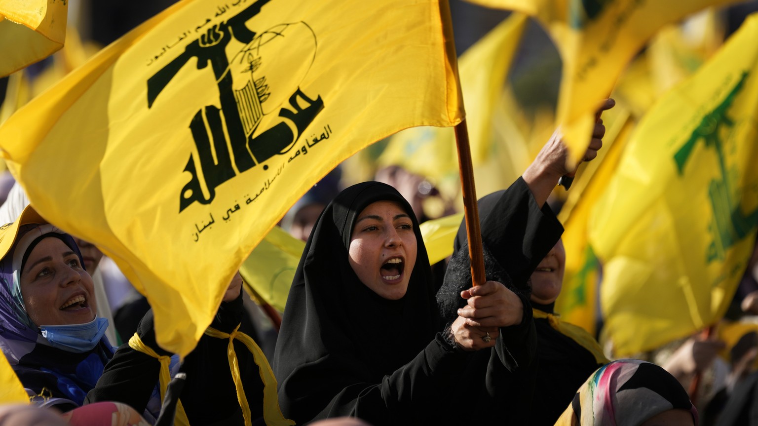 A Hezbollah supporter shouts slogans and waves her group flag, during an election campaign, in the southern suburb of Beirut, Lebanon, Tuesday, May 10, 2022. The parliamentary elections will take plac ...