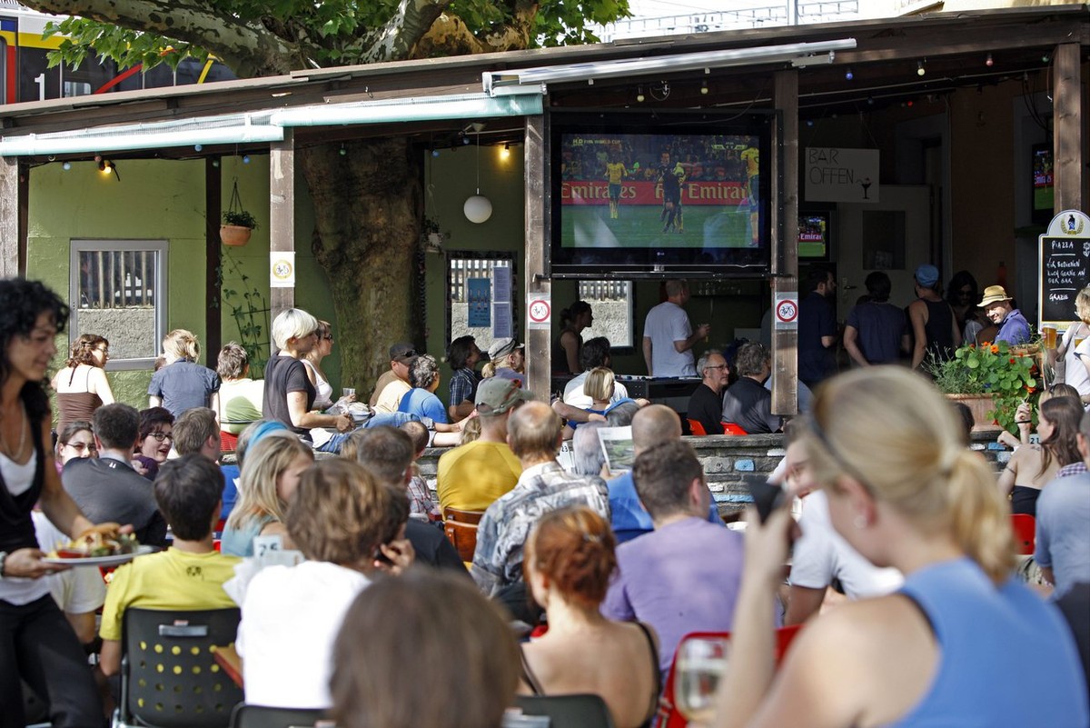 Fussballfans verfolgen das Eroeffnungsspiel der Fussball Weltmeisterschaft zwischen Suedafrika und Mexiko vor dem Restaurant "Piccolo Giardino" in Zuerich am Freitag, 11. Juni 2010. (KEYSTON ...