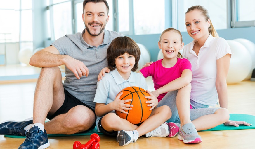 Die Stock-Foto-Familie macht Sport. Haben die eine Turnhalle gemietet? Oder ist das bei denen zuhause?