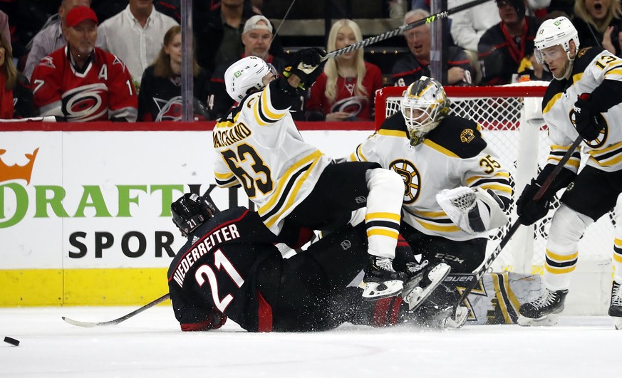 Carolina Hurricanes&#039; Nino Niederreiter (21) collides with Boston Bruins&#039; Brad Marchand (63) in front of goaltender Linus Ullmark (35) during the first period of Game 1 of an NHL hockey Stanl ...