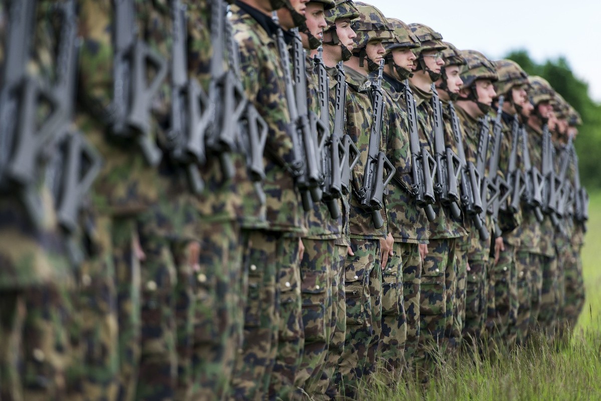 Infantry recruits stand in a row on a green field, pictured on May 17, 2013, in the infantry recruit school of the Swiss army in Colombier, canton of Neuchatel, Switzerland. (KEYSTONE/Christian Beutle ...