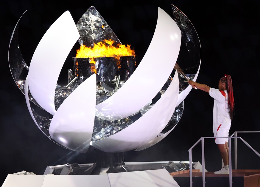 epa09360104 ..Japanese tennis player Naomi Osaka lights the flame of hope in the Olympic Cauldron during the Opening Ceremony of the Tokyo 2020 Olympic Games at the Olympic Stadium in Tokyo, Japan, 23 ...