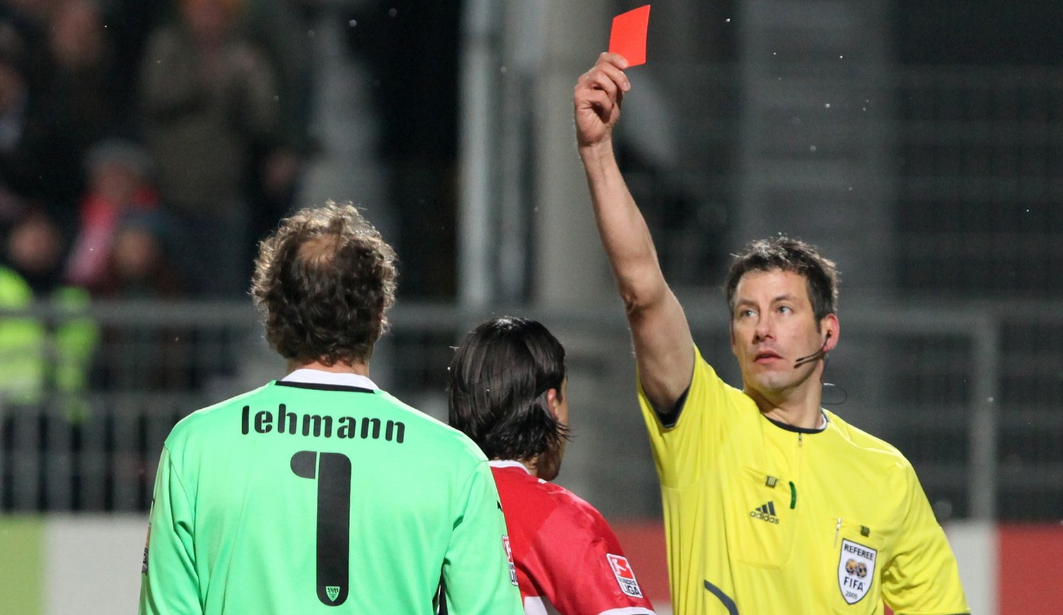 In this picture taken Dec. 13, 2009 referee Wolfgang Stark, right, shows a red card to former national goalie and Stuttgart's keeper Jens Lehmann, left, after tackling Aristide Bance, not in the pictu ...