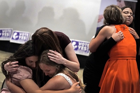 People hug during a Value Them Both watch party after a question involving a constitutional amendment removing abortion protections from the Kansas constitution failed, Tuesday, Aug. 2, 2022, in Overl ...