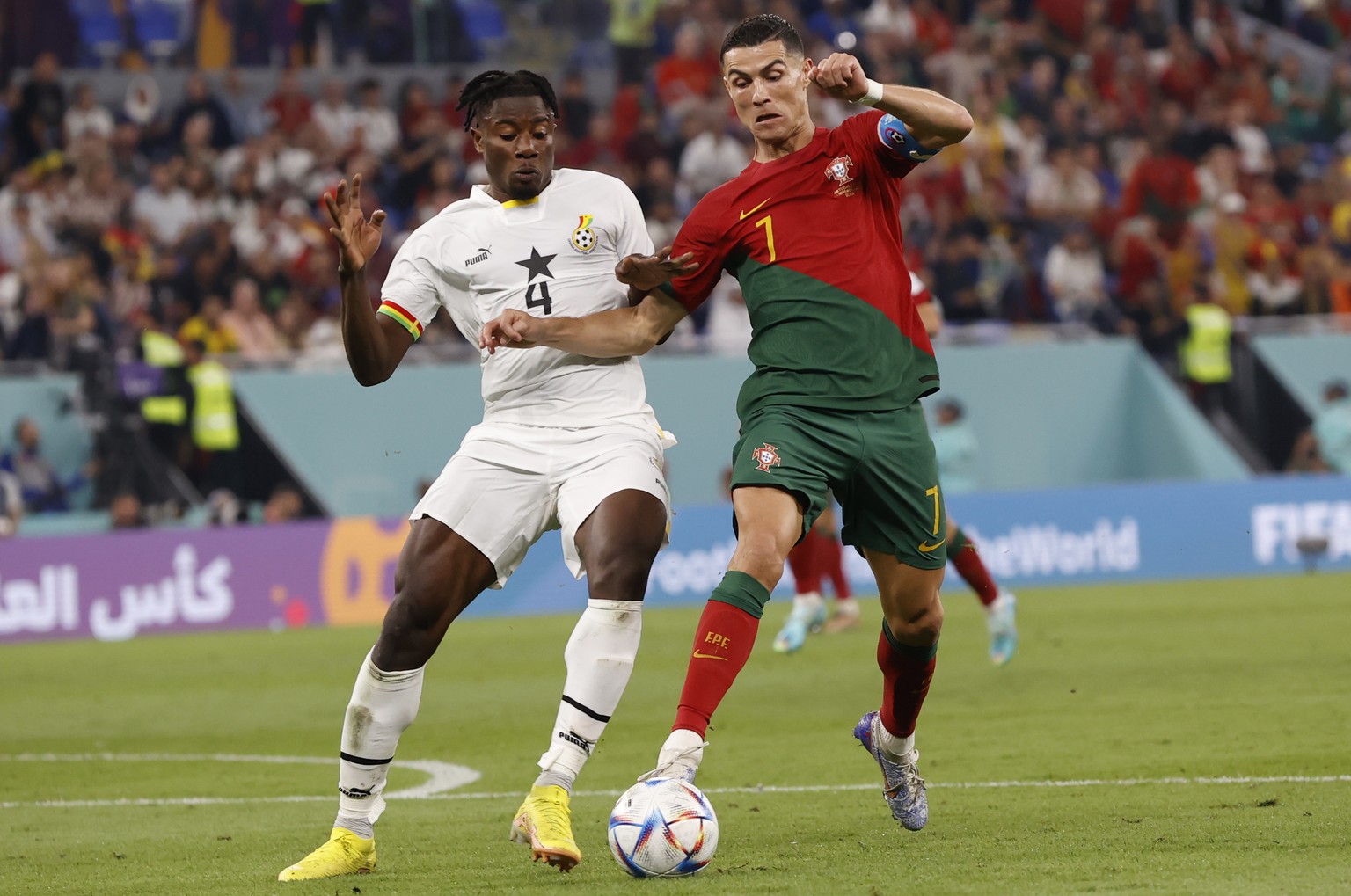 epa10325593 Mohammed Salisu of Ghana (L) tackles Cristiano Ronaldo of Portugal (R) resulting in a penalty during the FIFA World Cup 2022 group H soccer match between Portugal and Ghana at Stadium 947  ...