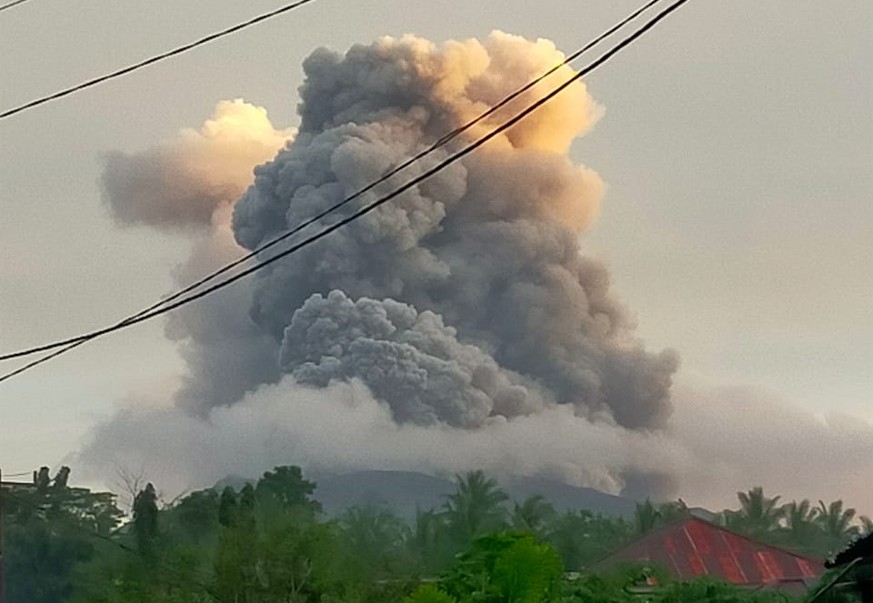 epa11288017 A handout photo made available by the Indonesian National Search and Rescue Agency (BASARNAS) shows smoke and ash erupting from Mount Ruang as seen from Tagulandang village, in North Sulaw ...