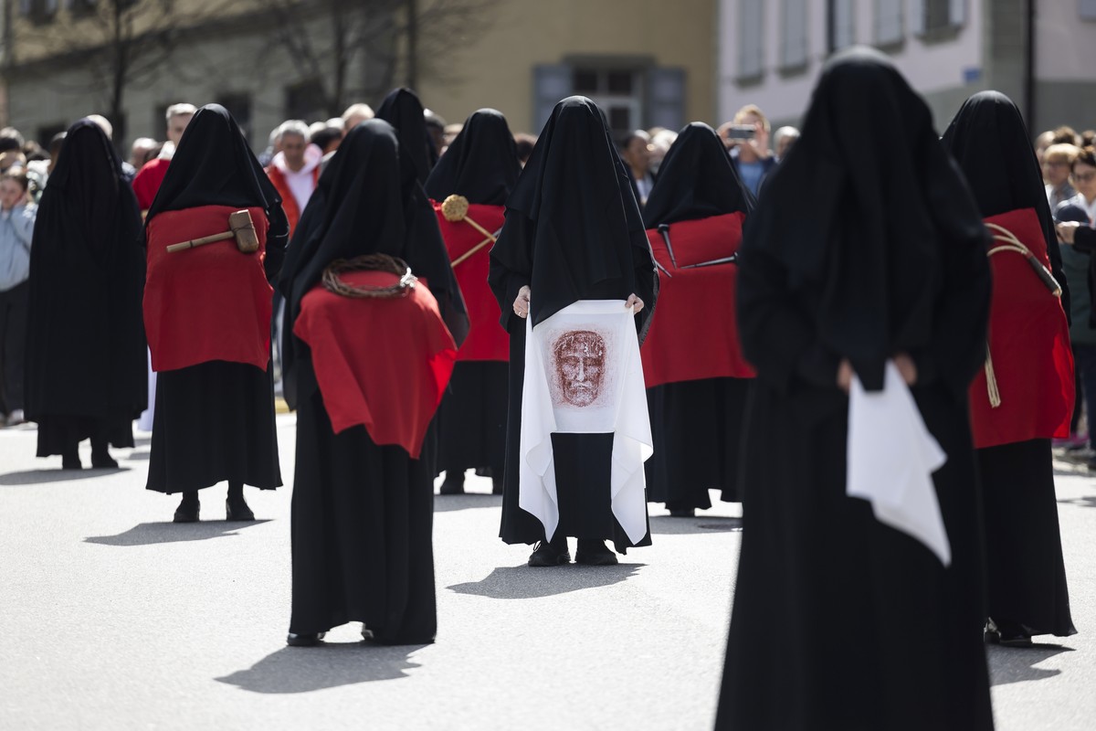 epa12039236 Women dressed in black veils and known as Les Pleureuses (the weepers) walk around the Collegiale de Notre-Dame de l'Assomption carrying wips, a thorn crown, nails and a shroud during ...