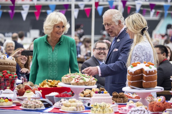 epa09997068 Britain&#039;s Prince Charles, the Prince of Wales (R) and Camilla Duchess of Cornwall (C) look at hand-sewn street party decorations as they attend The Big Lunch at the Oval Kennington to ...