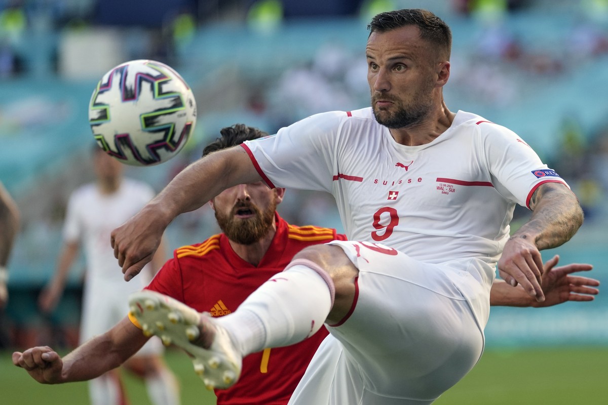 Switzerland's Haris Seferovic goes for the ball ahead of Wales' Joe Allen during the Euro 2020 soccer championship group A match between Wales and Switzerland, at the Baku Olympic stadium, i ...