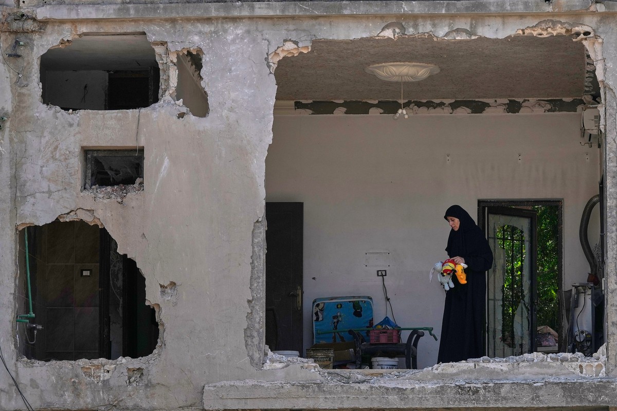 KEYPIX - A woman checks her damaged house at the site that was hit on Thursday in an Israeli airstrike in Arab Salim village, southern Lebanon, Friday, Aug. 28, 2026. (KEYSTONE/AP Photo/Mohammed Zaata ...