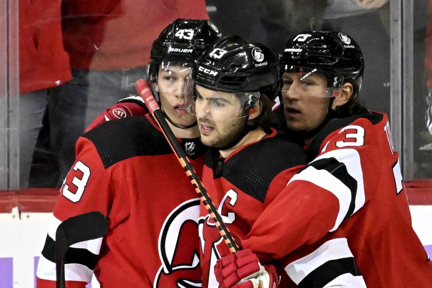 New Jersey Devils defenseman Luke Hughes, left, celebrates after his goal with Nico Hischier (13) and Tyler Toffoli (73) during the third period of an NHL hockey game against the Buffalo Sabres, Satur ...