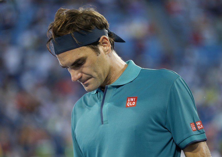 Roger Federer, oif Switzerland, packs up as rain begins to fall during the second set of his match against Juan Ignacio Londero, of Argentina, at the Western &amp; Southern Open tennis tournament in M ...