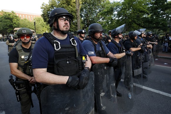 Member of government agencies stand on H Street as demonstrators gather to protest the death of George Floyd, Wednesday, June 3, 2020, near the White House in Washington. Floyd died after being restra ...