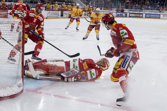 Biels Goalie Jonas Hiller, Mitte, deckt neben seinen Kollegen Luca Cunti, links, und Yannick Rathgeb, den Puck ab, im Eishockey Meisterschaftsspiel der National League zwischen dem EHC Biel und den SC ...