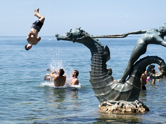 Die schÃ¶ne Seite des Hochsommers: Etwas abseits des Winzerfests kÃ¼hlen sich junge Menschen in Vevey VD im Genfersee ab.