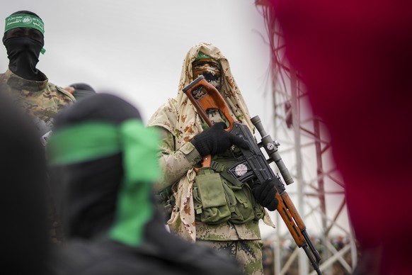 A Hamas fighter in combat fatigues stands before the ceremony for the handover of Israeli hostages to the Red Cross in Nuseirat, central Gaza Strip, Saturday, Feb. 22, 2025. (AP Photo/Abdel Kareem Han ...