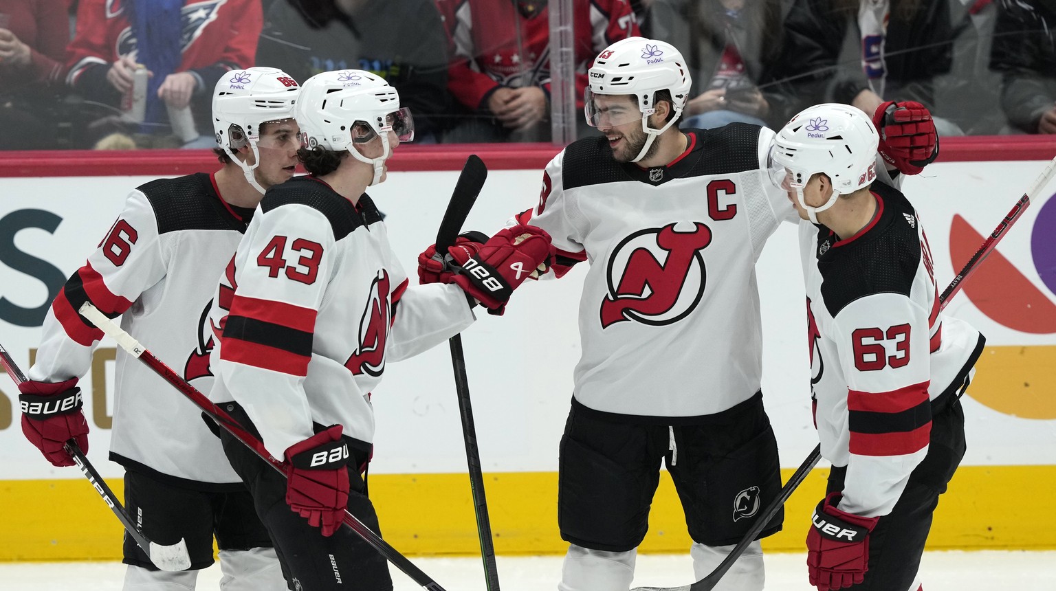 New Jersey Devils center Nico Hischier (13) is congratulated by center Jack Hughes (86), defenseman Luke Hughes (43) and left wing Jesper Bratt (63) after scoring his second goal against the Washingto ...