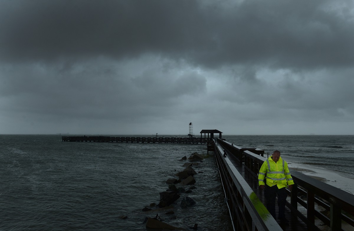 Cape Charles Police Department's Tom Potts walks back to his vehicle after checking out the fishing pier at Cape Charles, Va. on Saturday, Sept. 3, 2016. Tropical Storm Hermine lost hurricane str ...