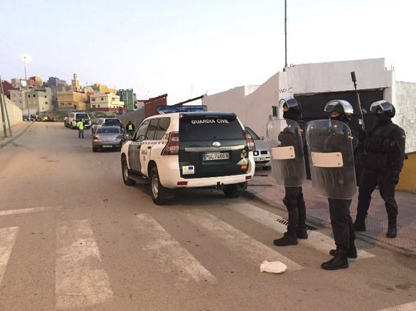 In this photo released by the Spanish Guardia Civil on Friday, Jan. 13, 2017, Spanish Guardia Civil officers stand guard in front of a house during a terrorist operation in Ceuta, Spain. Spanish polic ...