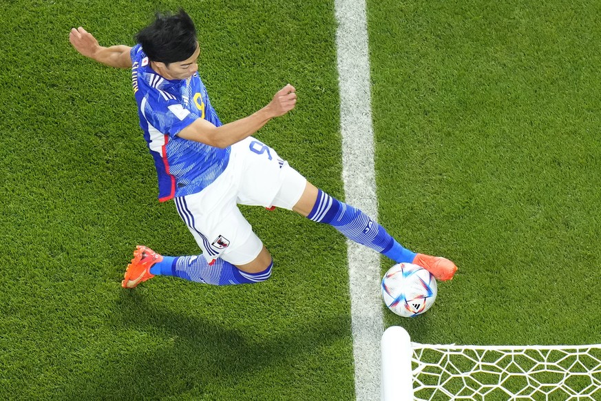 Japan's Kaoru Mitoma appears to have the ball over the line before crossing it for a goal during the World Cup group E soccer match between Japan and Spain, at the Khalifa International Stadium in Doh ...