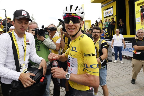 epa13132318 Yellow Jersey overall leader Slovenian cyclist Tadej Pogacar (C) of UAE Team Emirates XRG reacts in the finish area of Stage 20 of the Tour de France, a 170.9 km route from Le Bourg d' ...