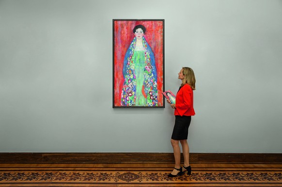 epa11105925 A handout photo made available by Auction House im Kinsky GmbH, Vienna, of a woman standing next to the painting &#039;Bildnis Fraeulein Lieser&#039; (Portrait of Miss Lieser) by Austrian  ...