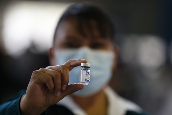 FILE - In this Feb. 24, 2021 file photo, a medical worker holds up a vial of the Sputnik V coronavirus vaccine, as the city health department conducts a mass vaccination campaign for Mexicans over age 60, at Palacio de los Deportes in Mexico City. Mexico will begin bottling and packaging the Russian vaccine, Mexico Foreign Affairs Secretary Marcelo Ebrard said Wednesday, April 28, 2021, during a visit to Russia. (AP Photo/Rebecca Blackwell, File)