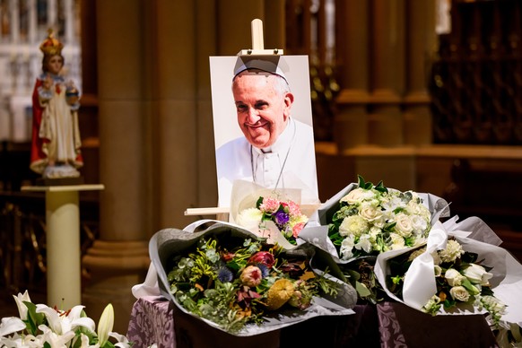 epa12056129 A photograph of Pope Francis with floral tributes during a vigil at St. Mary&#039;s Cathedral in Sydney, New South Wales, Australia, 26 April 2025. Pope Francis, who passed away on Easter  ...