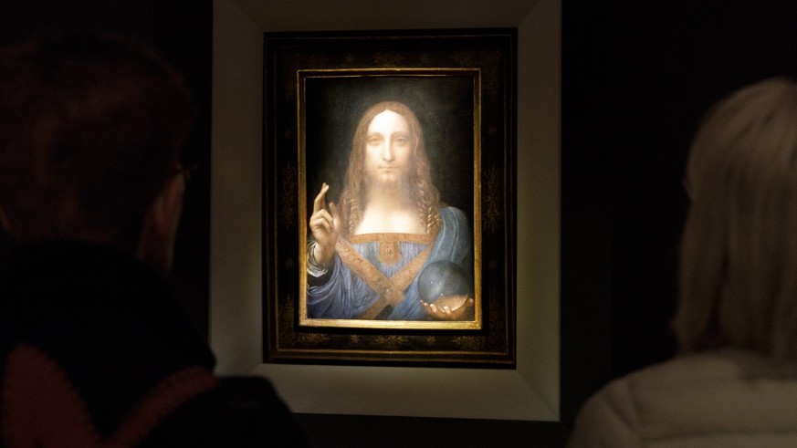 epa06331563 People look at the painting &#039;Salvator Mundi&#039; by Leonardo da Vinci (circa 1500) during a public preview before an auctioning of the painting tonight at Christie&#039;s auction hou ...