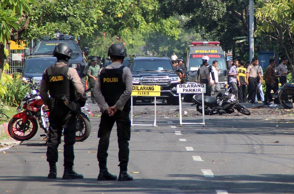 epa06732362 Indonesian bomb squad police officers inspect a blast site in front of a church in Surabaya, East Java, Indonesia, 13 May 2018. According to media reports, at least three people have been  ...