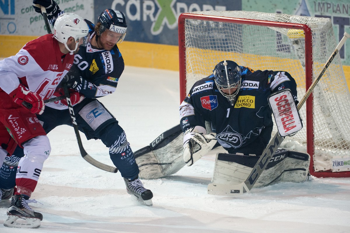 Lausanne's Alain Mieville, Ambri's player Franco Collenberg and Ambri's goalkeeper Benjamin Conz, from left, fight for the puck, during the preliminary round game of the National League ...