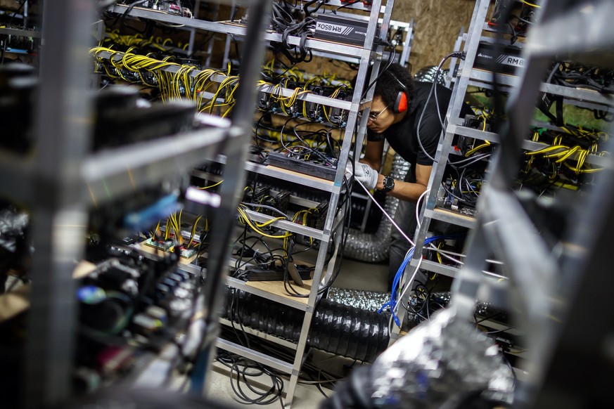 Alpine Mining employee Patrick Widmer is pictured between racks of computers in a cryptocurrency mine in the small alpine village of Gondo, Switzerland, Monday, May 7, 2018. The village formerly host  ...