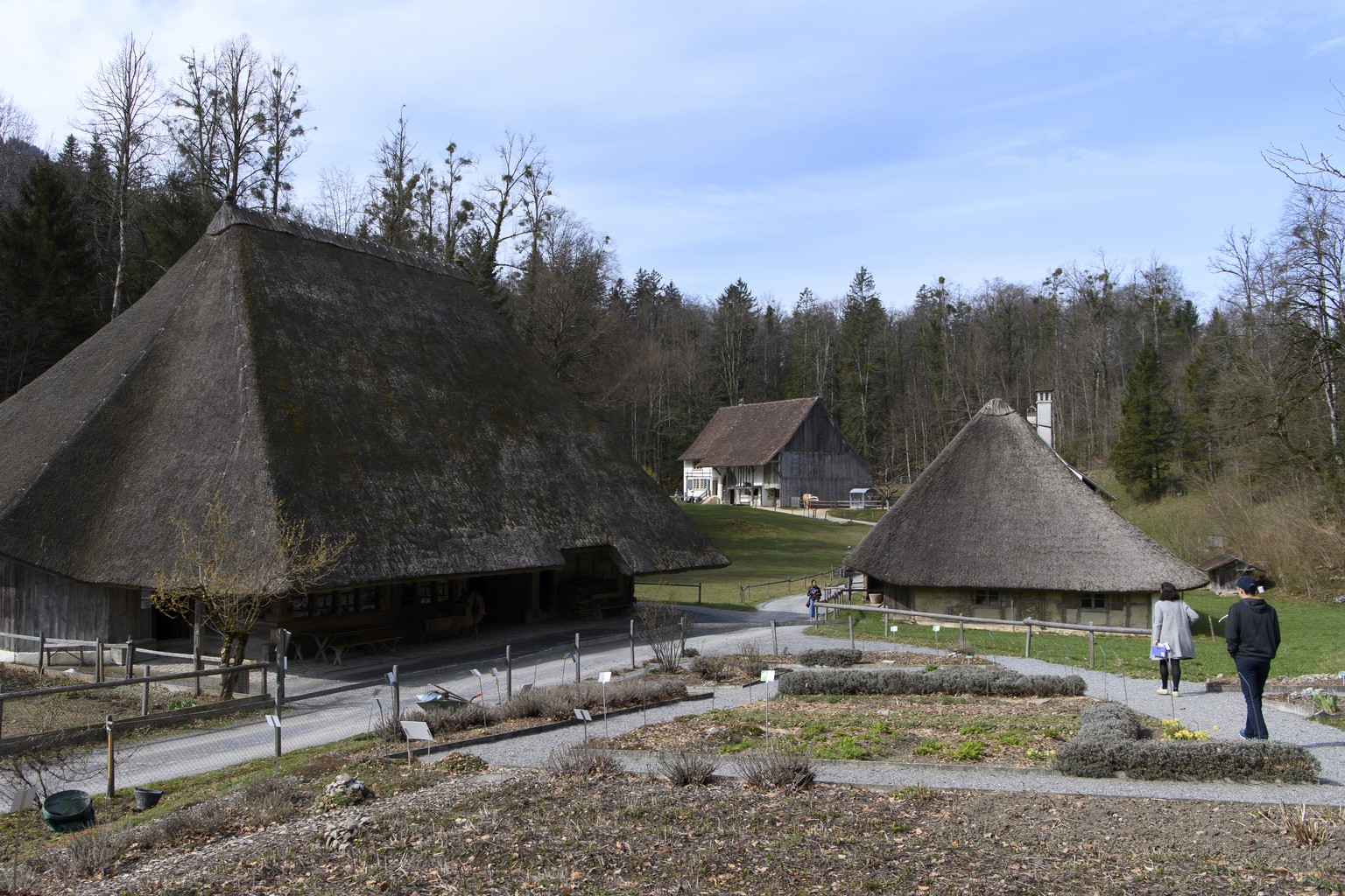 Menschen laufen vor einem Schweinestall aus Brugg (AG), links, und einem Tagloehnerhaus aus Leutwil (AG) rechts, herum, waehrend der Saisoneroeffnung des Freilichtmuseums Ballenberg, am Samstag, 10. A ...