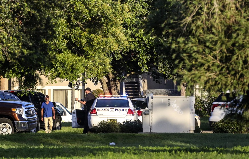 Police continue to work at the scene of a hostage standoff where a police officer was shot Monday morning, June 11, 2018, in Orlando. Police said a man suspected of battering his girlfriend wounded a  ...