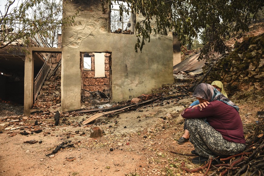 G?ols?om G?ol?�elik and her daughter cry in front of their house in Semir village, near Manavgat, Antalya, Turkey, Tuesday, Aug. 3, 2021. As fire crews' pressed ahead with their weeklong battle a ...