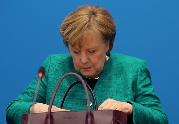 epa06564912 German Chancellor Angela Merkel looks into her handbag at the beginning of a Christian Democratic Union (CDU) party&#039;s chair board meeting at the CDU headquarter in Berlin, Germany, 25 ...