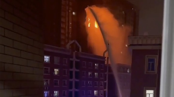 In this image taken from video, firefighters spray water on a fire at a residential building in Urumqi in western China's Xinjiang Uyghur Autonomous Region, Thursday, Nov. 24, 2022. A fire in an apart ...