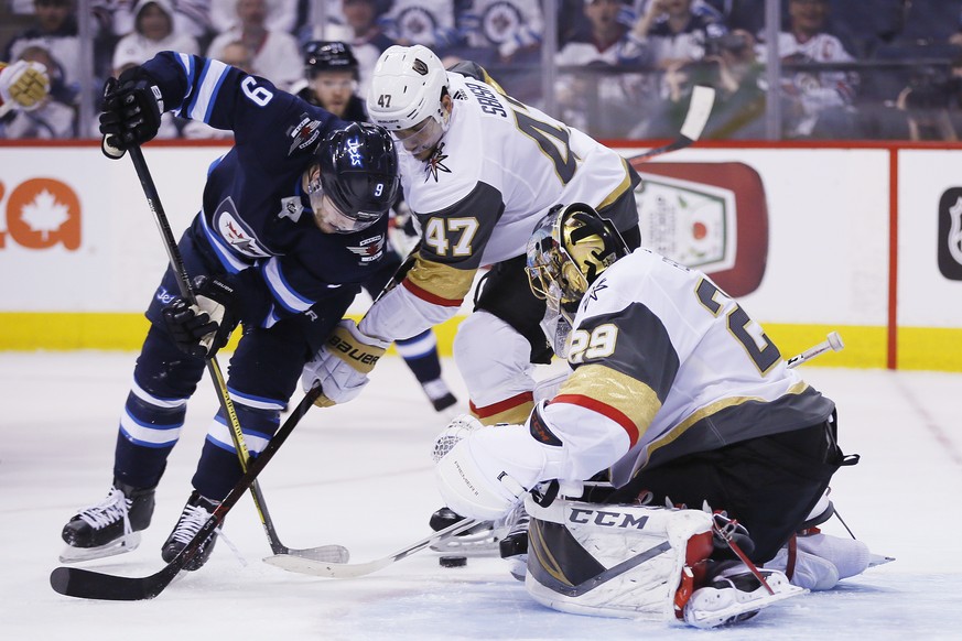 Vegas Golden Knights goaltender Marc-Andre Fleury (29) knocks the puck away from Winnipeg Jets&#039; Andrew Copp (9) as Knights&#039; Luca Sbisa (47) defends during the second period of Game 1 of the  ...